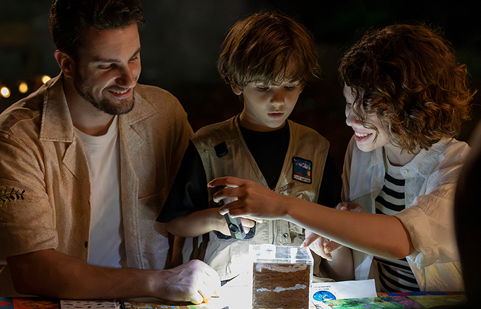 Person standing on rock formation with flashlight on